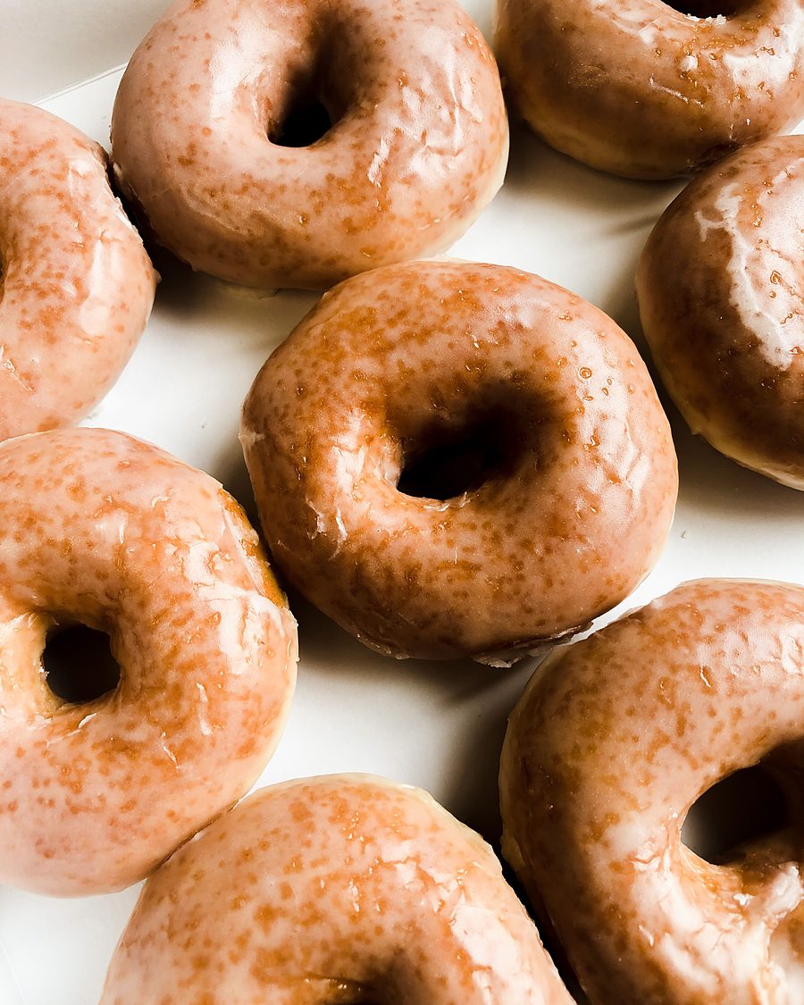 Licensed stock photograph: warm glazed ring donuts overlapping on a white plate